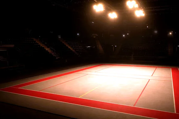 An empty kabaddi court under gold lights for CroreBet sports.